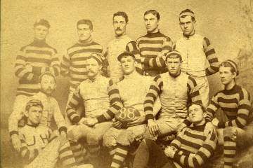 Sepia tone photo of 12 members of the 1888 football team in striped jerseys