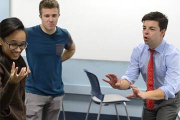 Three students participate in improv comedy exercise