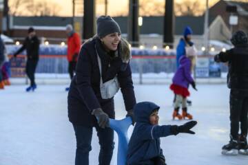 A mother and her child enjoy skating at the Ice Rink