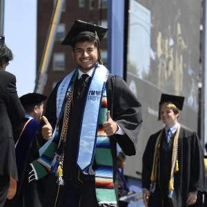 A student gives the thumbs up after walking across the stage to receive his Johns Hopkins degree