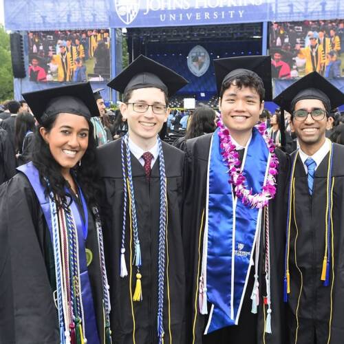 Four graduates pose for a photo