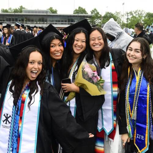 Five graduates pose for a photo